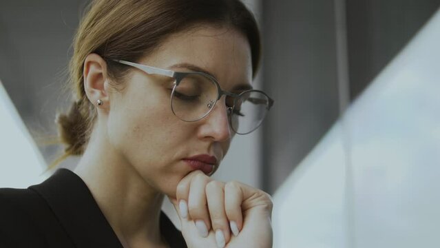 Young concentrated woman closing eyes and praying, asking God for health and blessing, feeling nervous before important event and trying to calm down closing her eyes, close-up