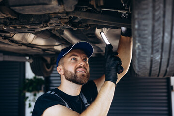 Auto mechanic lifting car and doing check up on car service