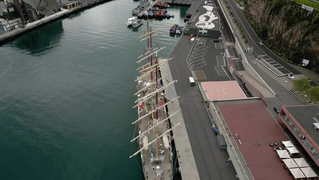 Masted Ship Docked On The Coast Of Funchal In Madeira, Portugal. aerial descend