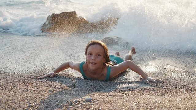A Child Girl in a Swimsuit Playing and Having Fun in the Oncoming Wavess