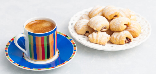 Cookies with nuts and a small, colored cup of coffee