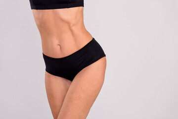 Cropped portrait of sportive great shape aged lady fit hips stomach empty space ad isolated on grey...