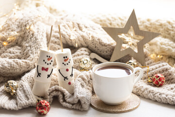 Winter composition with a cup of cocoa and marshmallows on a blurred background.