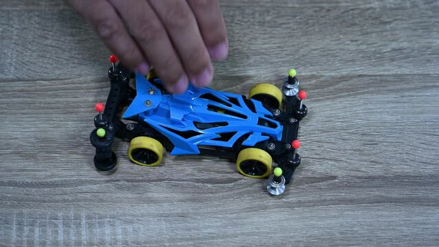 A blue modified racer picked up and dropped many times, Tamiya Mini 4X4