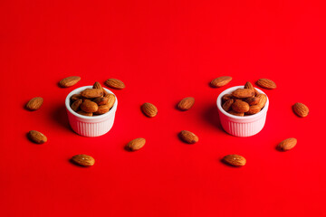 Almonds seed in white cup on red background