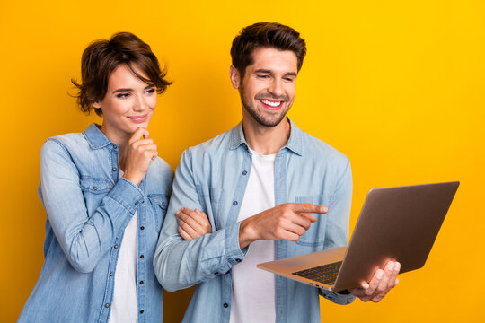 Photo of two workers working netbook writing project pointing screen isolated bright color background