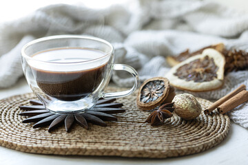 Composition with a cup of coffee on a blurred background with a knitted element.