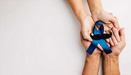 Supporting Prostate Cancer Awareness in November with a light Blue Ribbon and mustache on a blue...
