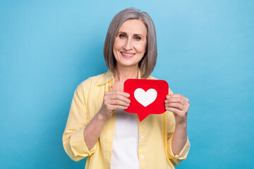 Photo of adorable pretty lady wear yellow shirt holding feedback heart card isolated blue color...