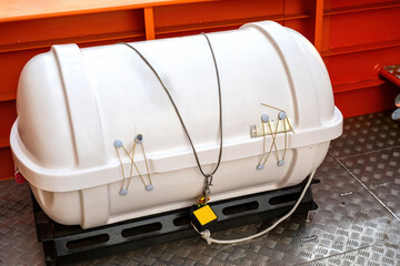 Container with inflatable boat on deck. White tank is locked. Rescue equipment on board ship. Boat deck. Lifeboat release tray. Safety measures on cruise ship. Ship equipment for emergency situations