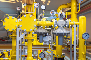Gas equipment. Yellow pipes with pressure gauges. Gas compressor station. Propane recycling system. Gas equipment inside boiler room. Equipment for space heating. Boiler technology