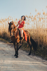 Cheerful woman riding horse in countryside