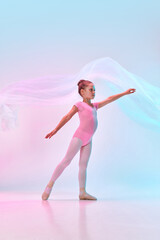 Portrait of small cute tender ballerina dancer girl wearing leotard and pointe posing with flying...