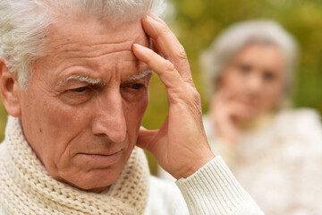 Portrait of an old man having a headache 