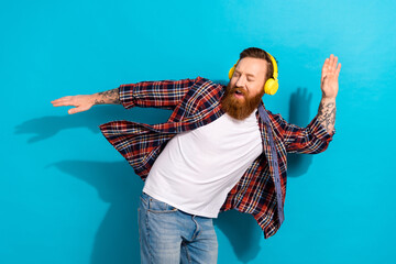 Portrait of crazy funky man with tattoo wear plaid shirt dancing in headphones listen upbeat music...