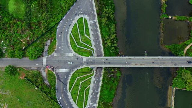 Aerial footage of a traffic intersection at a bridge over a river.  Traffic and architectural concepts.