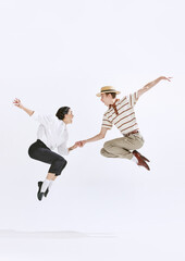 Cheerful, positive young people, man and woman dancing retro dance, having fun isolated on white studio background. Concept of art, hobby, retro dance, vintage style, choreography, beauty. Ad