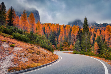 Dramatic morning view of National Park Tre Cime di Lavaredo with asphalt road. Gloomy autumn landscape in Dolomite Alps, South Tyrol, Location Auronzo, Italy, Europe. Traveling concept background..