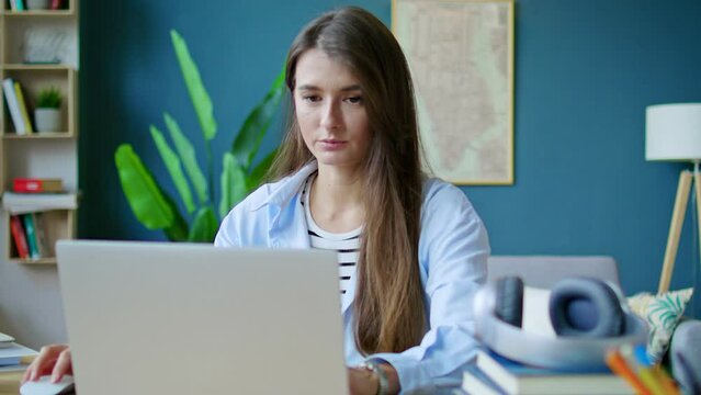 Positive thoughtful young female entrepreneur drinking coffe or tea, studying financial report on laptop. Businesswoman looking at office web-pages with work result, business flowering.