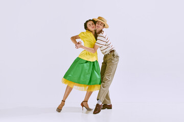 Love. Beautiful young woman and handsome young man dancing together isolated on white studio...