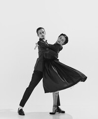 Elegance in movements. Black and white. Beautiful couple, man and woman in stylish clothes dancing....