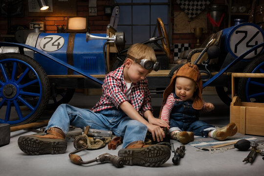 Little boys play in the garage and pretend they are mechanics. Children imagine themselves as racers in a retro car and dream of adventure and travel.