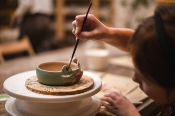 girl hands, pottery studio and painting cup in workshop for sculpture