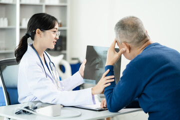 Obraz premium Female doctor consulting patient using x-ray film analyzed the results of medical reports, talking to patient and touching patient hand and consoling.