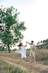 Fototapeta premium Playful and youthful adult man and woman having fun together in the meadow.