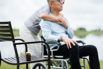 Obraz premium Romantic senior woman embracing man sitting on wheelchair. Elderly people take care of each other.