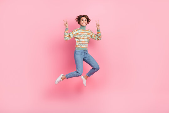 Full length picture of jumping funky girl bob brown hair showing two v sign symbols peace sportive isolated on pink color background