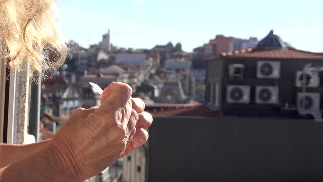 Porto, Portugal A woman files her nails outside a window overlooking the Ribeira district. 