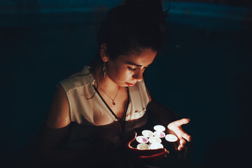 Woman swimming in pool with candles