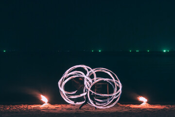 Fire steel wool with water reflection on sea in beach club party at night Samui Thailand - 652255400