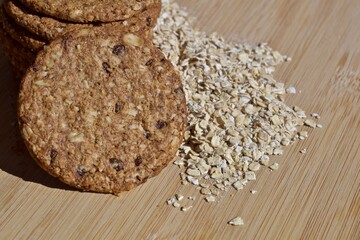 oatmeal cookies on a wooden base with the shadow of an ear of oats