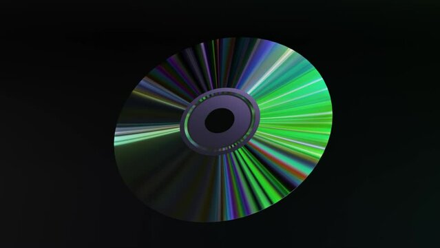 Abstract concept. The CD DVD spins on a black background. Rainbow. Green neon color. 
