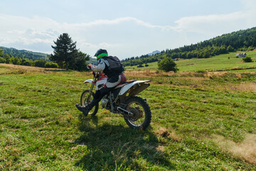 Fototapeta premium A motorcyclist equipped with professional gear, rides motocross on perilous meadows, training for an upcoming competition.
