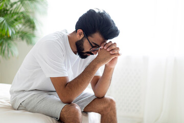 Impotence Concept. Upset Pensive Young Indian Man Sitting On Bed At Home
