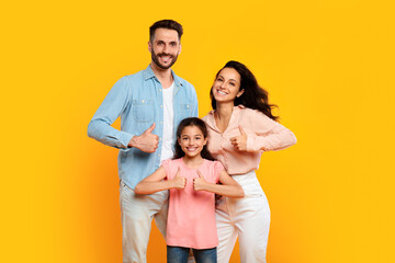 We like it. Portrait of smiling european family of three showing thumbs up gesture, approving or recommending something