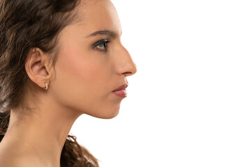Profile portrait of a beautiful serious young woman, a nose with a hump on white background