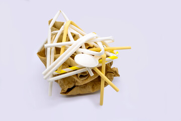 Pile rubbish  of disposable paper straws, teaspoon paper and paper plate on white background. Waste...