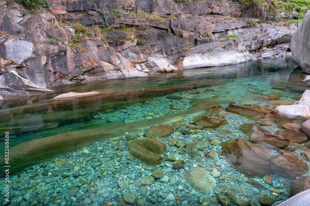 Aufkleber the clear water of a stream flows between rocks and trees