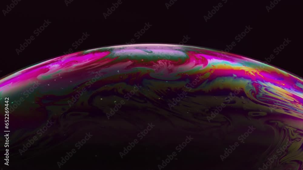 Poster abstract concept. the multi-colored iris of a soap bubble is in motion. rainbow bubble on a dark bac