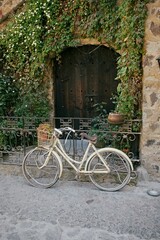 Fototapeta na wymiar Vintage-looking bicycle parked outside a classic Italian-style house, with colorful shutters