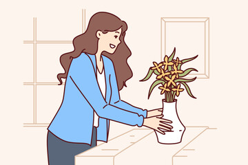 Woman does home staging and puts vase of flowers on table to prepare apartment for sale or rent. Girl designer provides home staging services for property owners wishing to make good deal