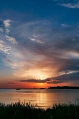Vertical shot of a beautiful orange sunset reflecting on the ocean water