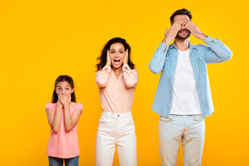 Hear no evil, see no evil, speak no evil. Family of three people covering eyes, ears and mouth,...