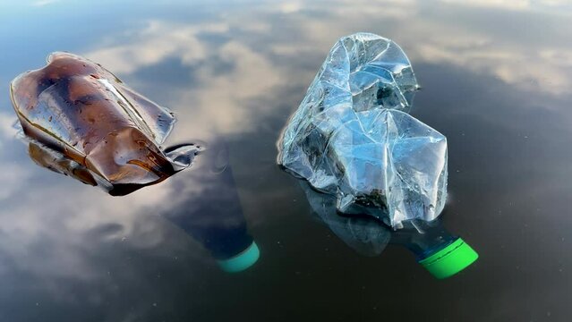 Plastic bottle garbage on sea shore lake. Collecting waste and garbage on beach. Waste Plastic bottle for recycling and re-use. Plastic bottles as pollution. People throws garbage and waste in ocean.
