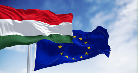 Flags of Hungary and the European Union fluttering together on a clear day