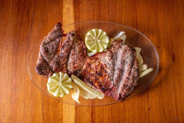 a plate of meat with limes on a table top